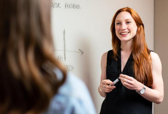 Woman smiling and having a conversation with a colleague.